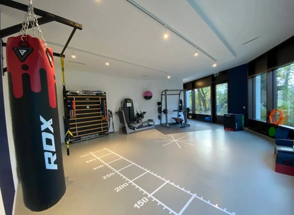La salle d'entraînement lumineuse du cabinet KS Therapy à Genève, avec ses grandes baies vitrées